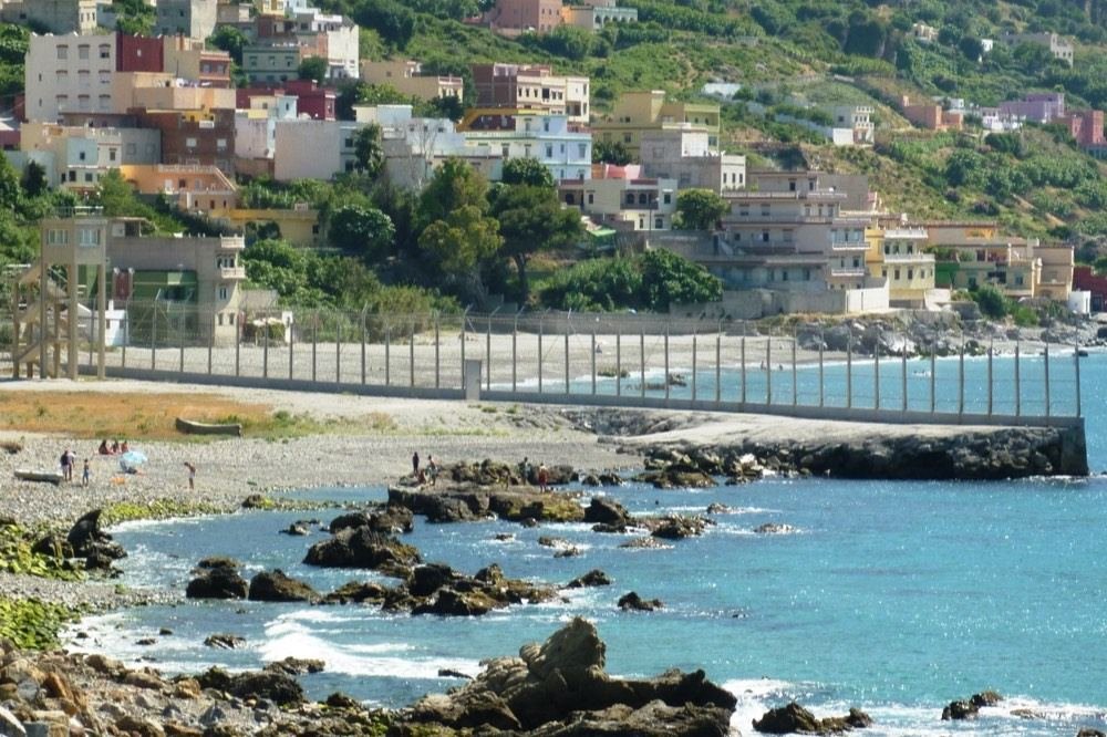 El vallado del perímetro fronterizo de Ceuta. Es exactamente aquello de lo que habla la disposición adicional décima: «los elementos de contención fronterizos». Se elige la valla vacía y no una imagen de personas saltándola a propósito: el artículo explica el régimen jurídico y no toma partido, y esa otra fotografía lo inclinaría antes de la primera línea.